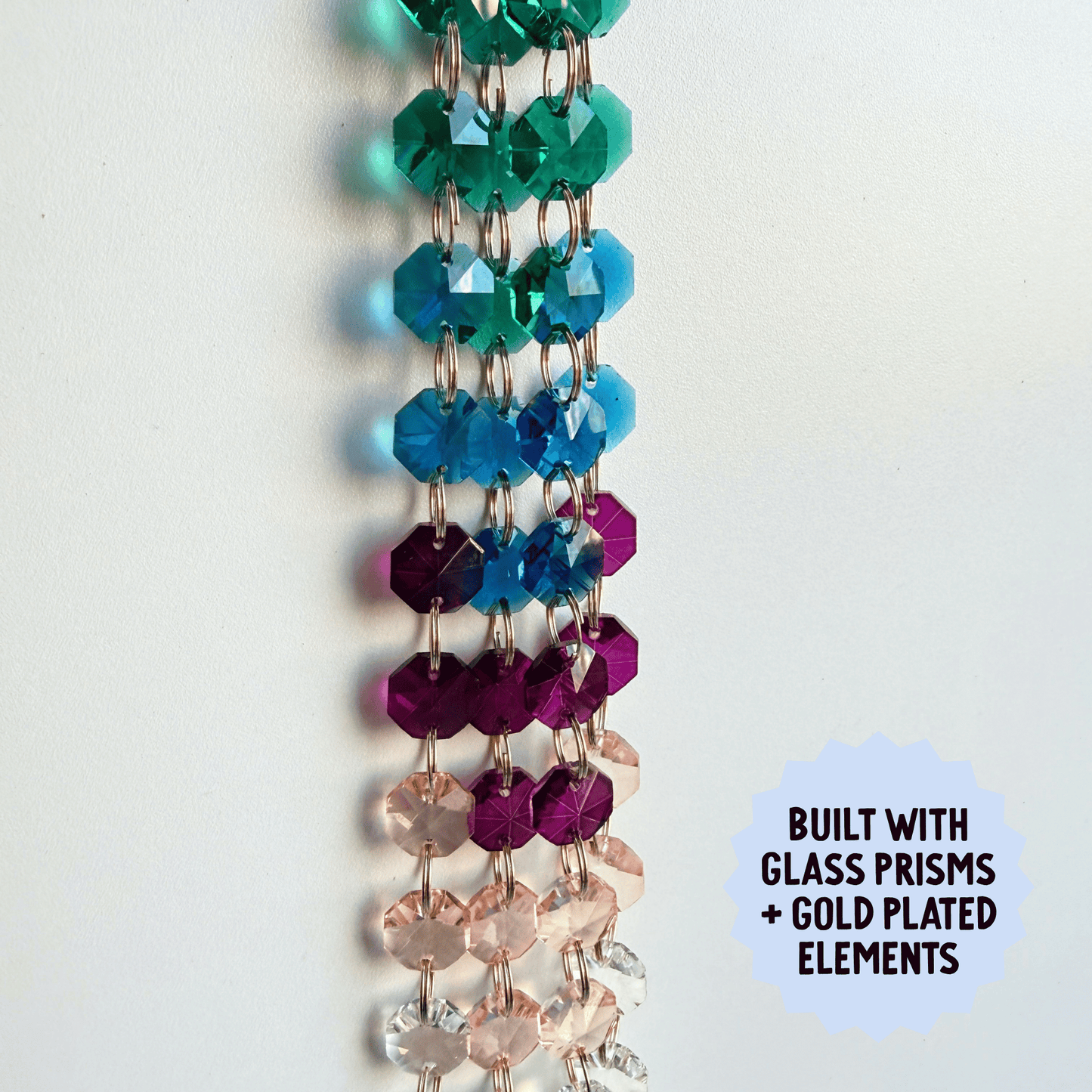 Colorful beaded suncatcher with glass prisms and gold plating on a white background