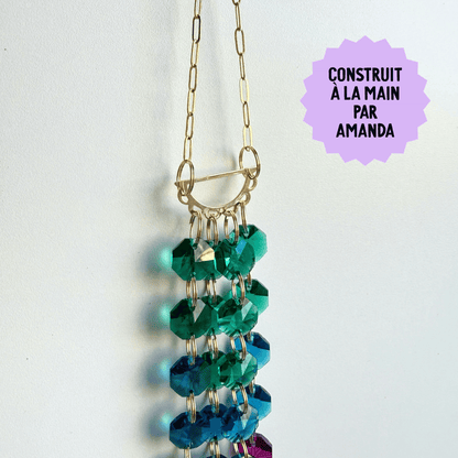 beaded suncatcher with green and blue beads on a white background, labeled 'Construit  La Main Par Amanda'.